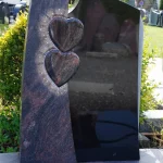Urnengrabanlage zweifarbig, Indora satiniert, schwarzer Granit poliert, Symbolik: zwei Herzen