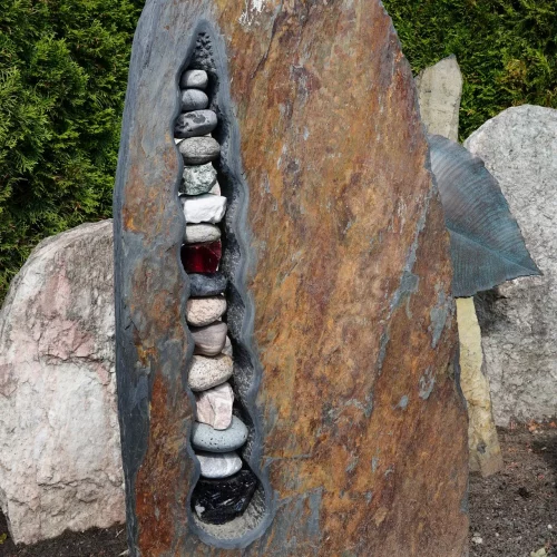 Stele aus gespaltenem Schiefer-Bruch, rostig mit eingefügten Steinen