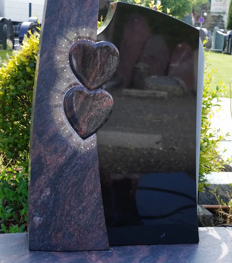 Urnengrabanlage zweifarbig, Indora satiniert, schwarzer Granit poliert, Symbolik: zwei Herzen